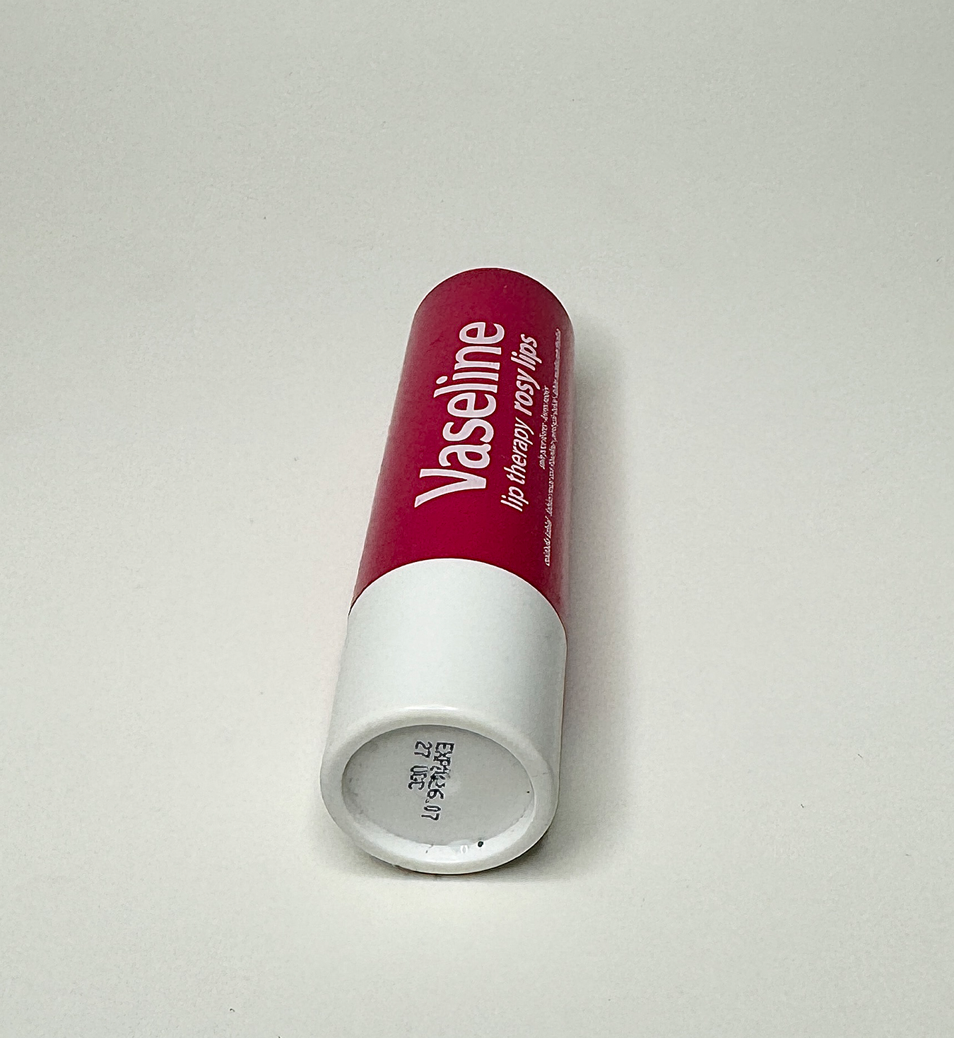 Image of pink vaseline lip balm on its side